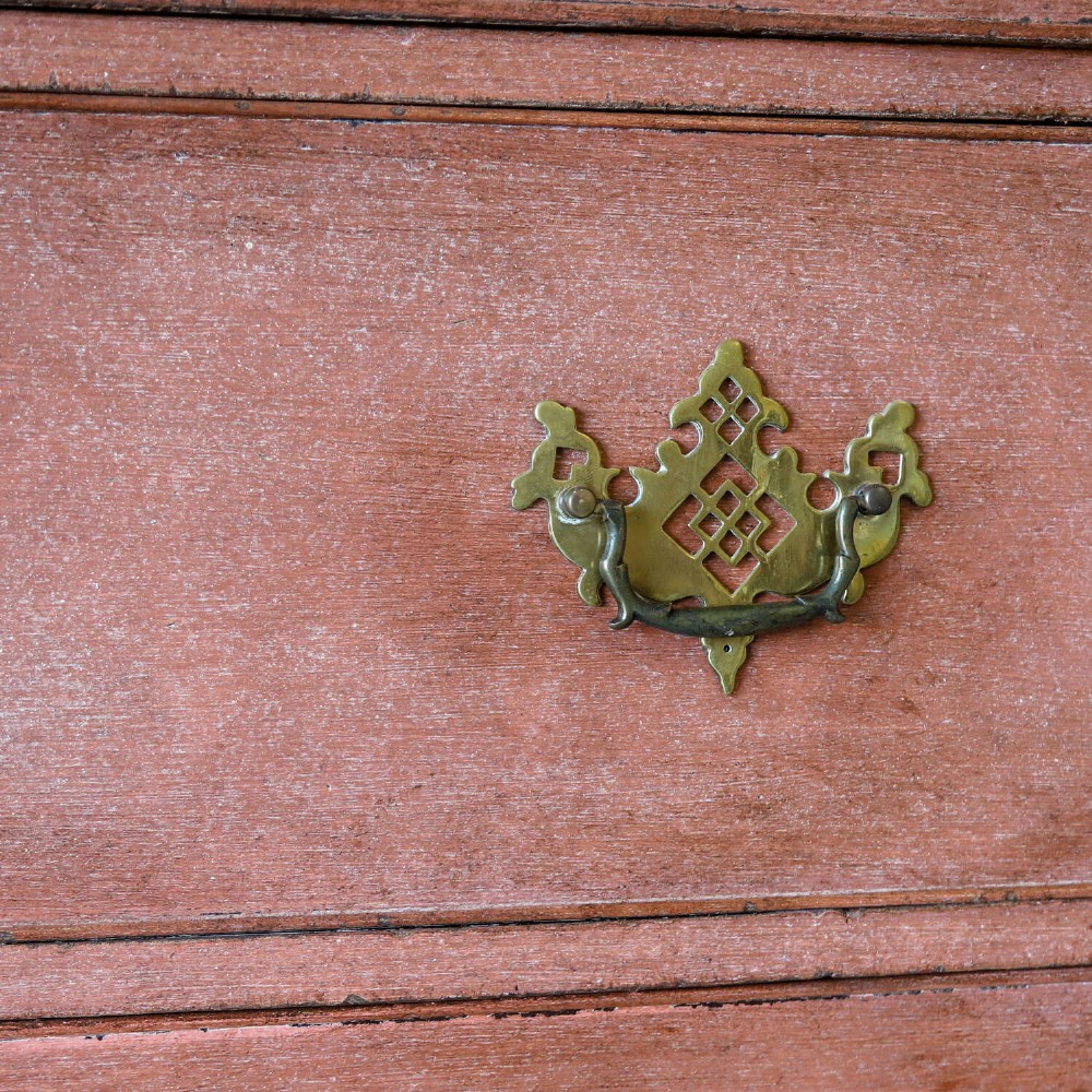 An eighteenth-century Georgian chest on chest with a distressed terracotta painted finish, brass pierced handles, and bracket feet. View V