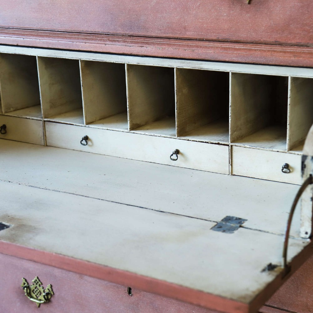 An eighteenth-century Georgian chest on chest with a distressed terracotta painted finish, brass pierced handles, and bracket feet. View X