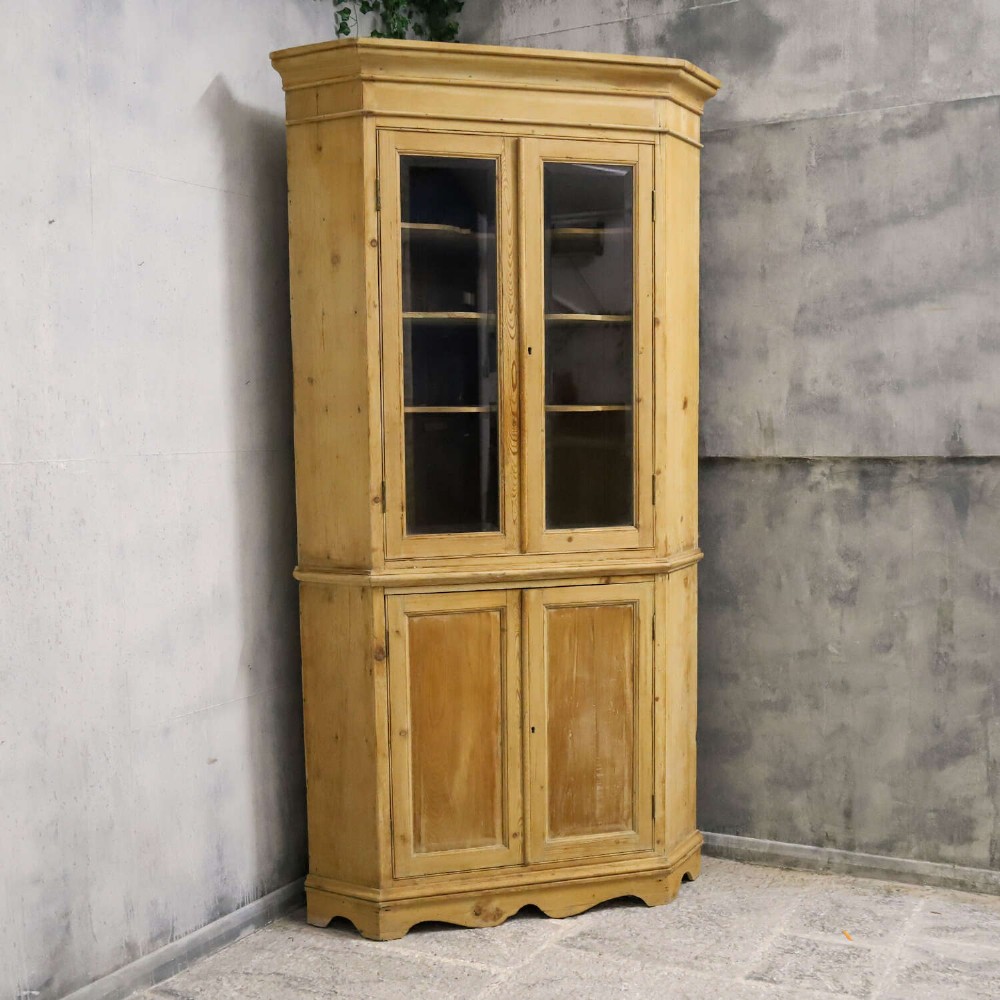 A nineteenth-century two-part pine corner cupboard featuring glazed upper doors and panelled lower doors with a shaped apron. View III