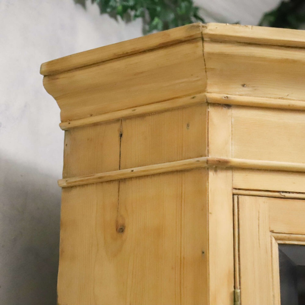 A nineteenth-century two-part pine corner cupboard featuring glazed upper doors and panelled lower doors with a shaped apron. View V