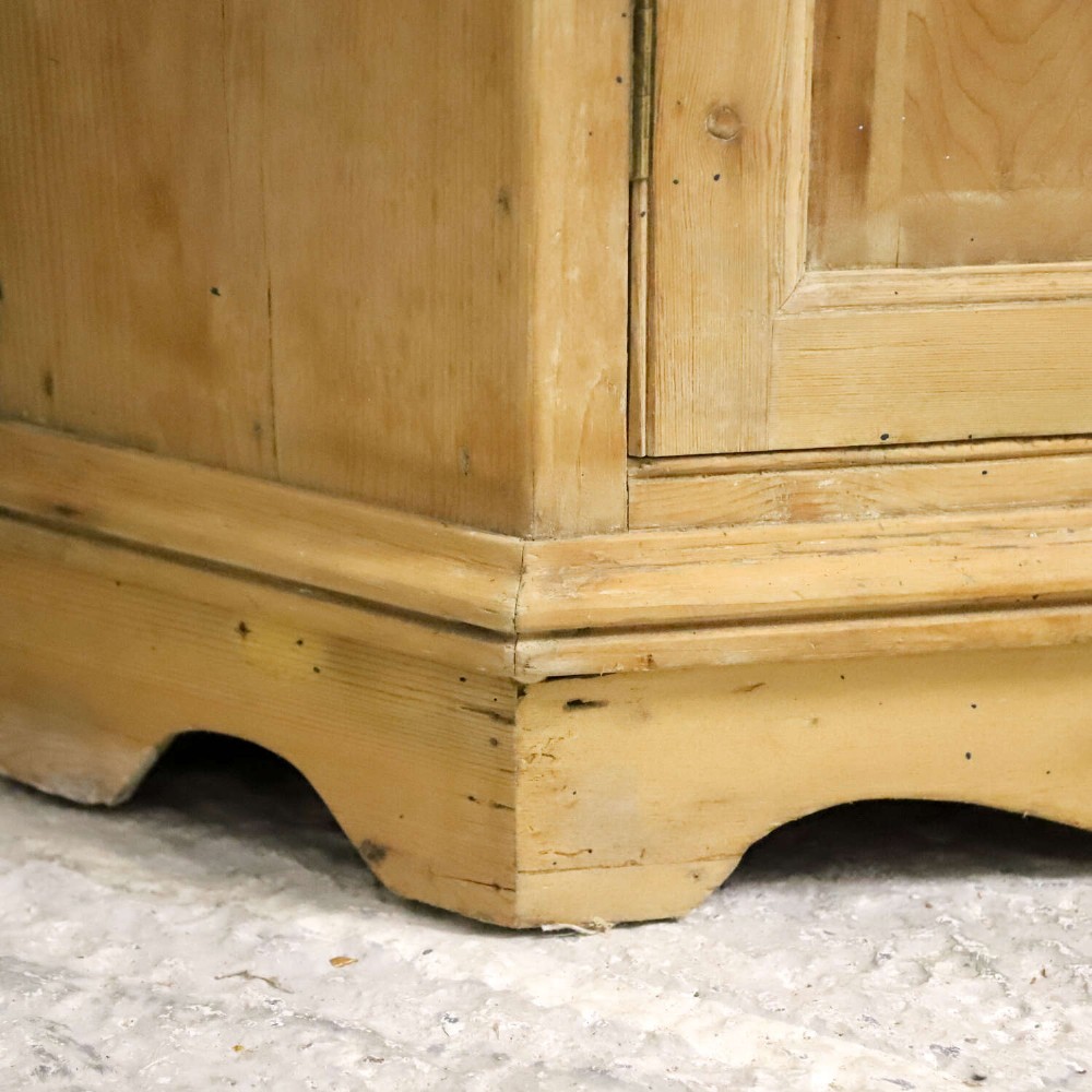 A nineteenth-century two-part pine corner cupboard featuring glazed upper doors and panelled lower doors with a shaped apron. View VI
