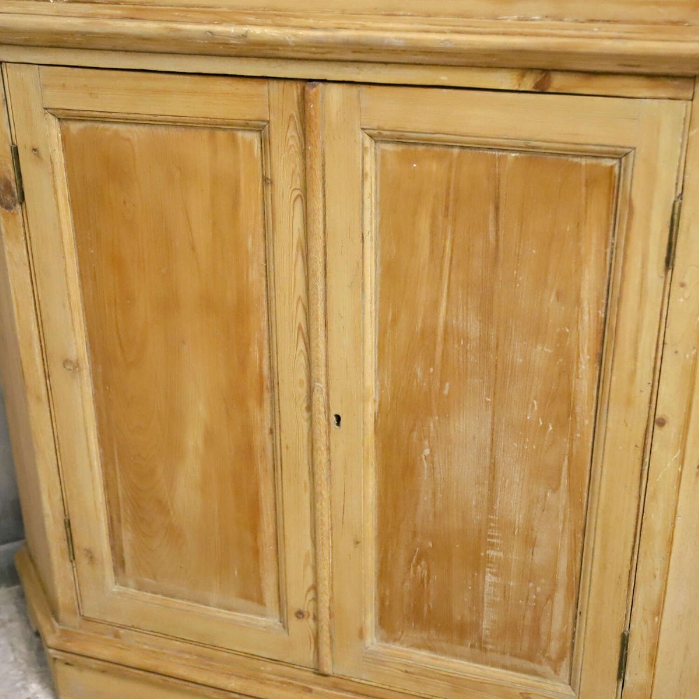 A nineteenth-century two-part pine corner cupboard featuring glazed upper doors and panelled lower doors with a shaped apron. View VIII