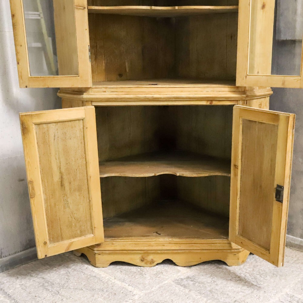 A nineteenth-century two-part pine corner cupboard featuring glazed upper doors and panelled lower doors with a shaped apron. View XII