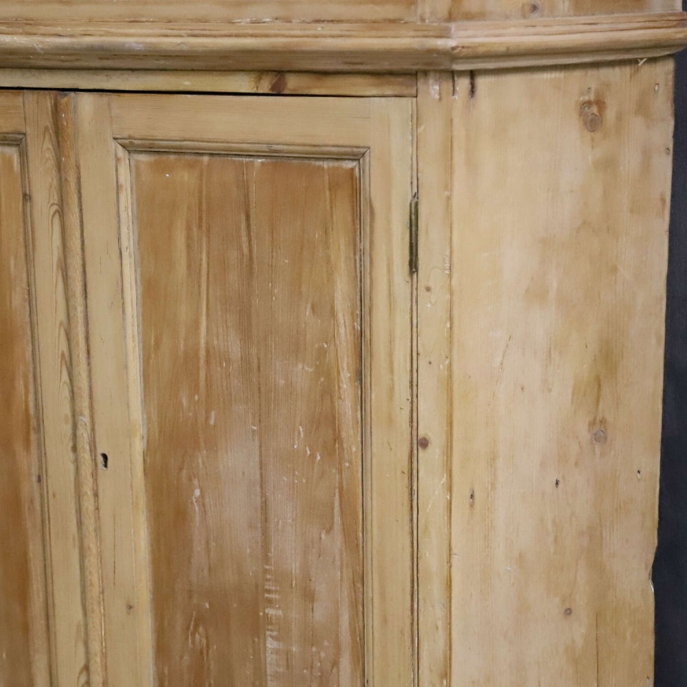 A nineteenth-century two-part pine corner cupboard featuring glazed upper doors and panelled lower doors with a shaped apron. View XIV