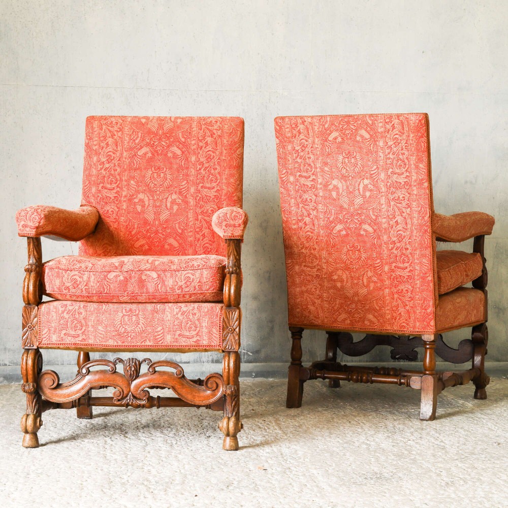 A pair of late nineteenth-century French Renaissance Revival oak armchairs upholstered in terracotta patterned fabric with carved scrolled stretchers and turned legs. View II