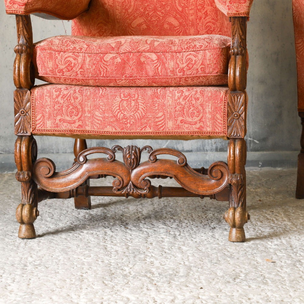 A pair of late nineteenth-century French Renaissance Revival oak armchairs upholstered in terracotta patterned fabric with carved scrolled stretchers and turned legs. View III