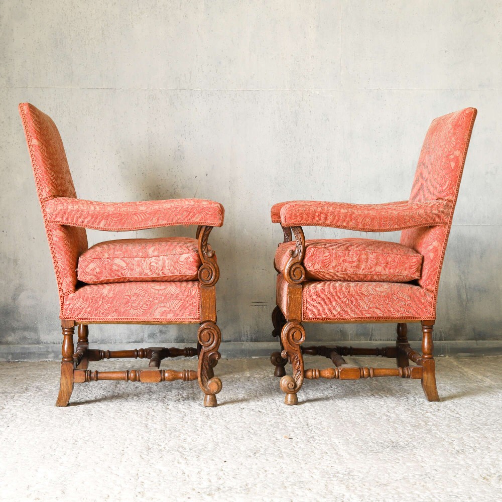 A pair of late nineteenth-century French Renaissance Revival oak armchairs upholstered in terracotta patterned fabric with carved scrolled stretchers and turned legs. View IV