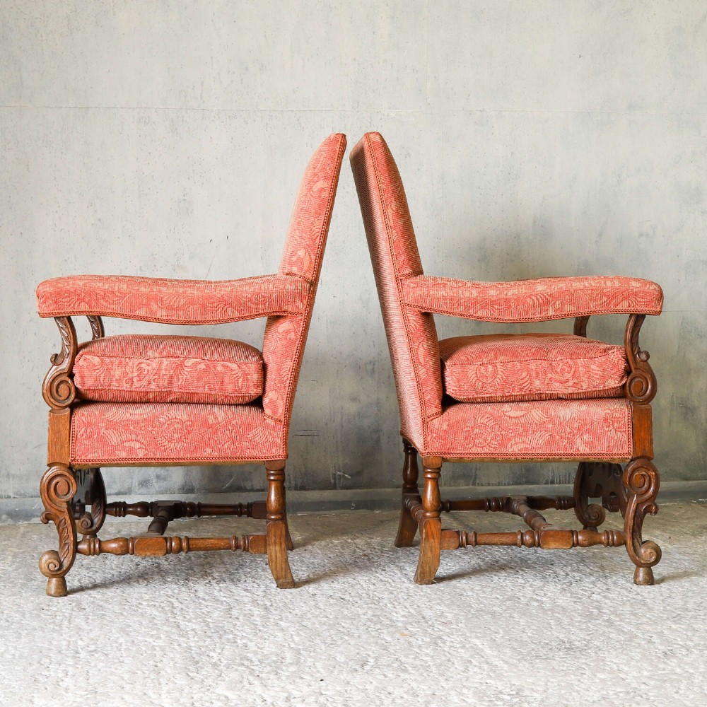 A pair of late nineteenth-century French Renaissance Revival oak armchairs upholstered in terracotta patterned fabric with carved scrolled stretchers and turned legs. View VI