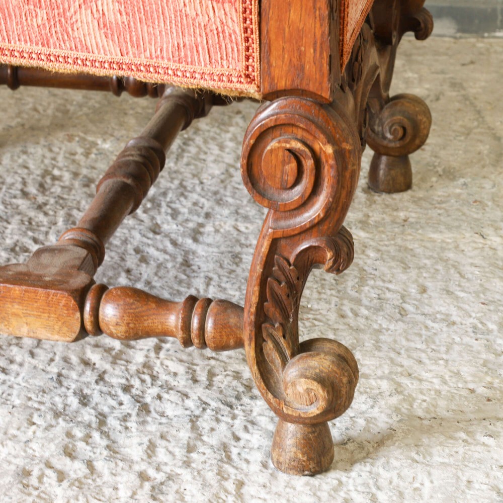 A pair of late nineteenth-century French Renaissance Revival oak armchairs upholstered in terracotta patterned fabric with carved scrolled stretchers and turned legs. View VII