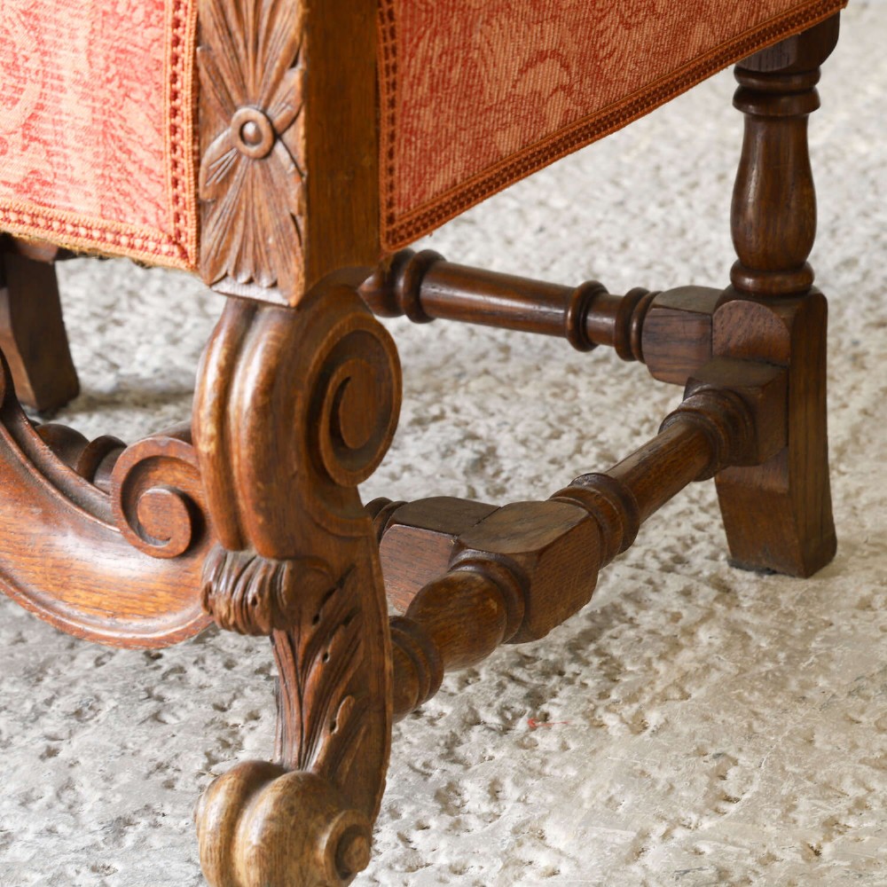 A pair of late nineteenth-century French Renaissance Revival oak armchairs upholstered in terracotta patterned fabric with carved scrolled stretchers and turned legs. View XV
