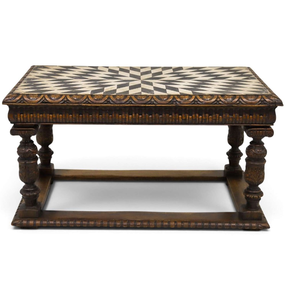 A 19th-century carved oak centre table featuring turned baluster legs, a stretcher base, and a geometric black and white painted starburst top.