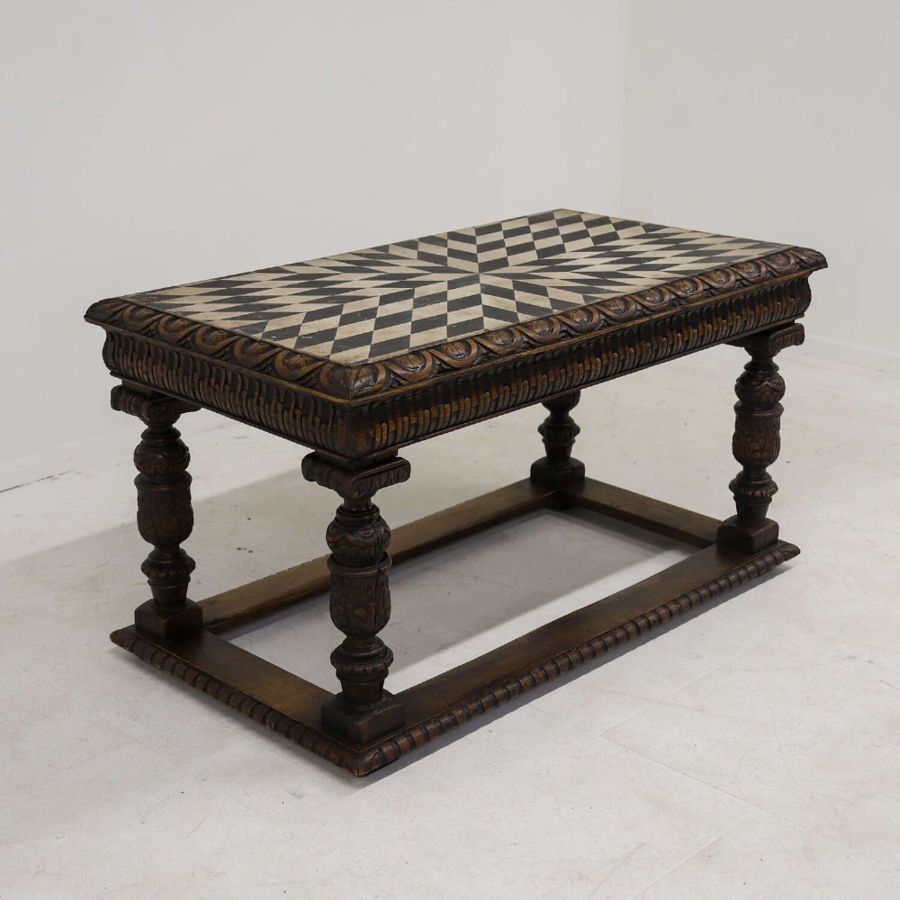 A 19th-century carved oak centre table featuring turned baluster legs, a stretcher base, and a geometric black and white painted starburst top. View III
