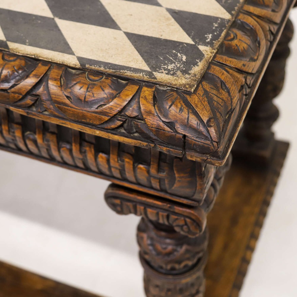 A 19th-century carved oak centre table featuring turned baluster legs, a stretcher base, and a geometric black and white painted starburst top. View V