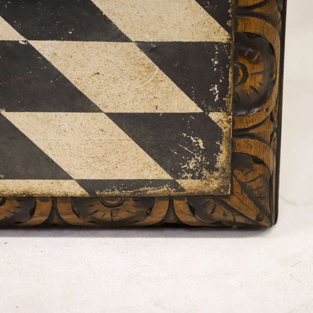 A 19th-century carved oak centre table featuring turned baluster legs, a stretcher base, and a geometric black and white painted starburst top. View XI