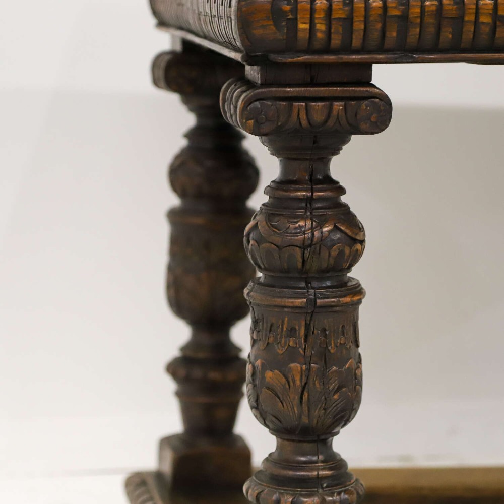 A 19th-century carved oak centre table featuring turned baluster legs, a stretcher base, and a geometric black and white painted starburst top. View XIII