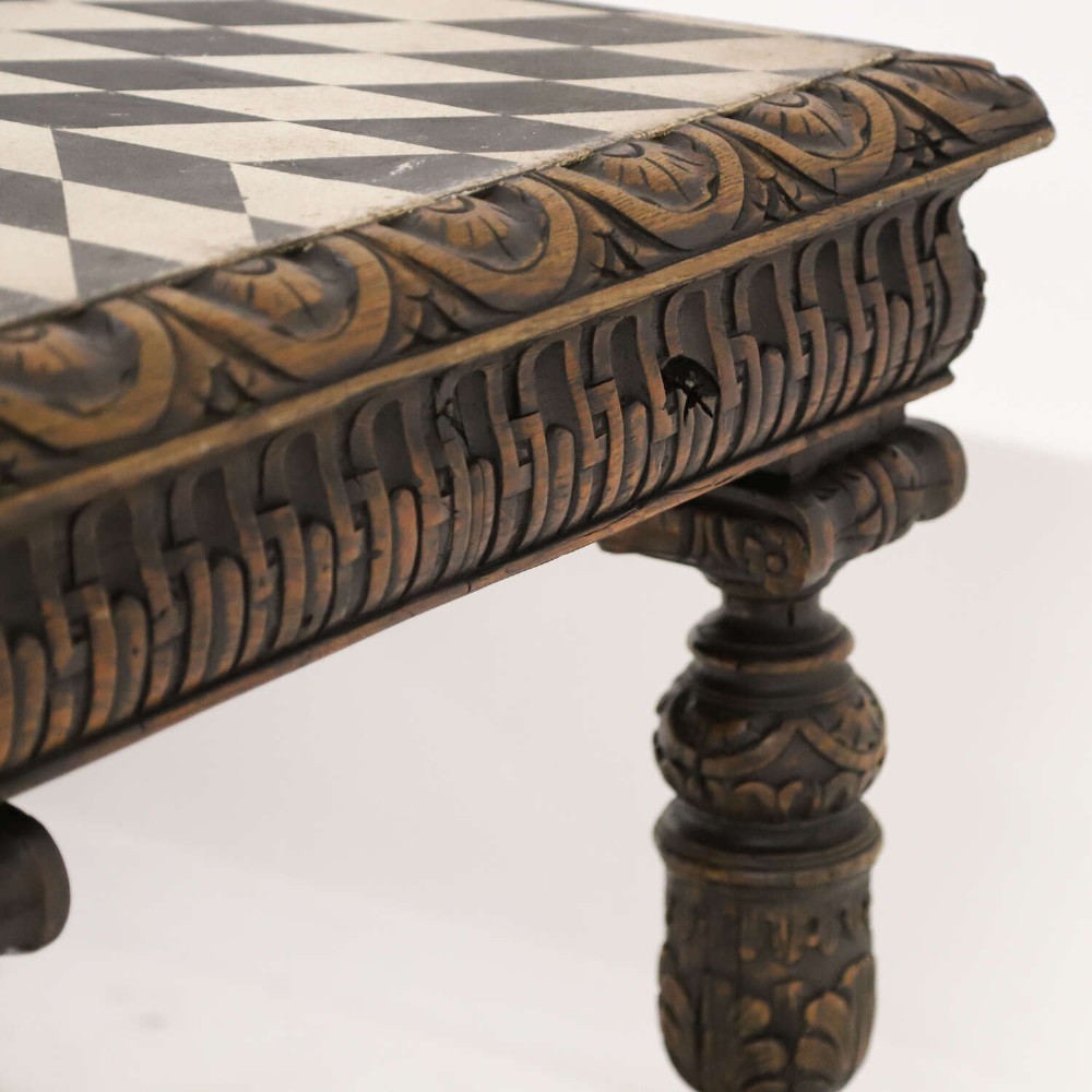 A 19th-century carved oak centre table featuring turned baluster legs, a stretcher base, and a geometric black and white painted starburst top. View XV