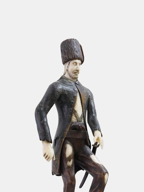 fig 1. An 18th-century carved boxwood and ivory figure of a standing male figure on a naturalistic rocky base.