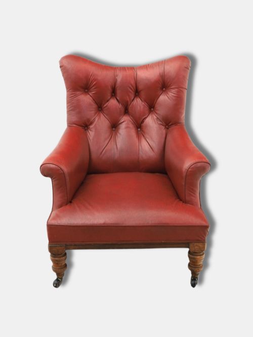 fig 1. A pair of 1920s English armchairs upholstered in red oxblood rexine with deep buttoning and turned wooden legs on castors.