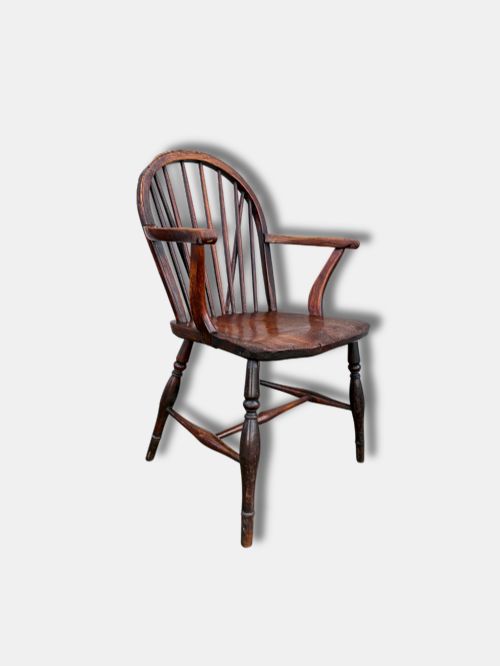 fig 1. A dark brown antique Thames Valley Windsor armchair made of timber featuring a hoop back with spindles, curved armrests, a shaped solid seat, and turned legs.