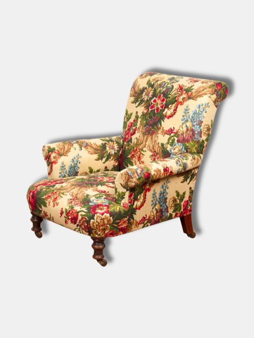 fig 2. A Victorian mid-19th century armchair upholstered in cream floral fabric with turned dark timber front legs on brass castors.