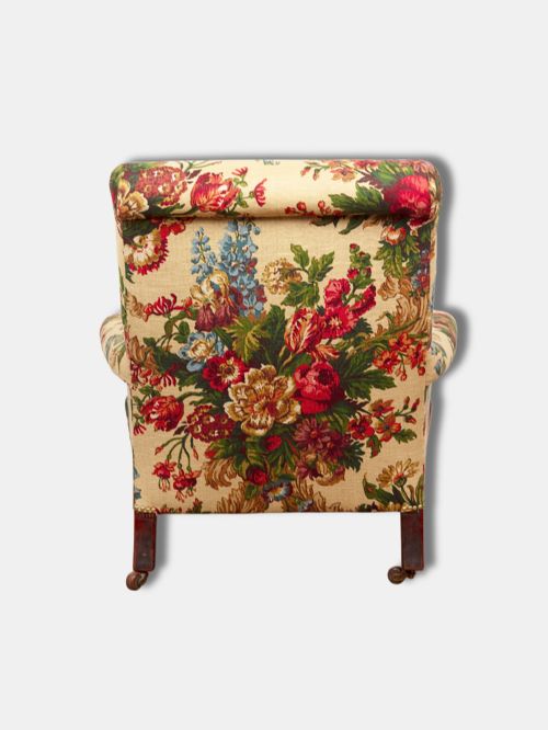 fig 3. A Victorian mid-19th century armchair upholstered in cream floral fabric with turned dark timber front legs on brass castors.