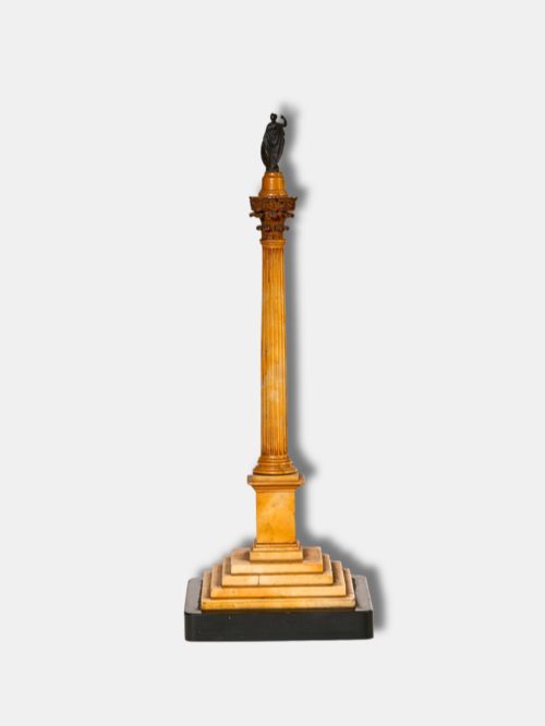 fig 1. A detailed miniature architectural model of the Column of Phocas carved from yellow Giallo Antico marble with a small bronze figure atop, set upon a stepped square base.
