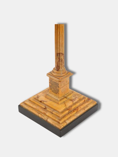 fig 2. A detailed miniature architectural model of the Column of Phocas carved from yellow Giallo Antico marble with a small bronze figure atop, set upon a stepped square base.