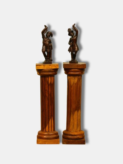 fig 1. A pair of warm brown turned hardwood column pedestals featuring fluted shafts, square capital tops, and moulded square bases.