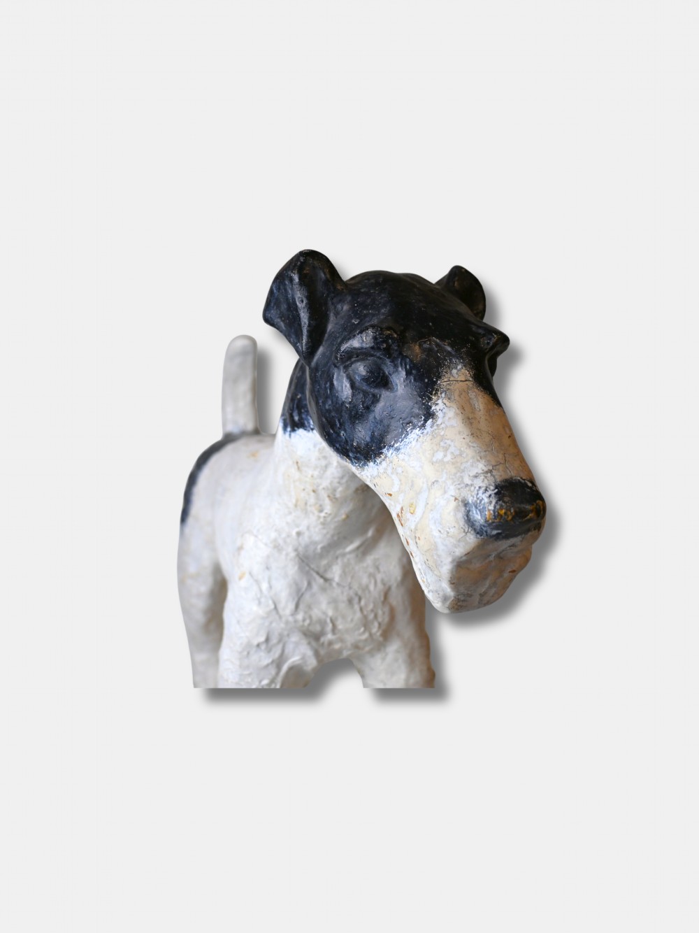 A life-size 1920s composition figure of a Fox Terrier featuring an off-white body, black painted markings on the head and back, and the name Osmond impressed into the shoulder. View III