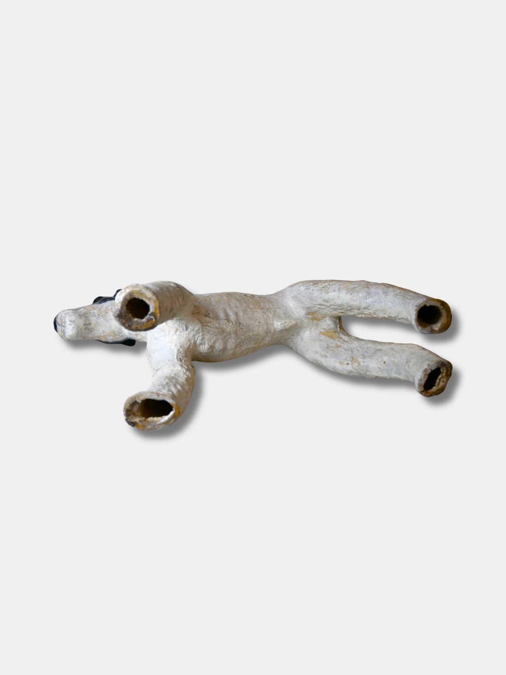 A life-size 1920s composition figure of a Fox Terrier featuring an off-white body, black painted markings on the head and back, and the name Osmond impressed into the shoulder. View V