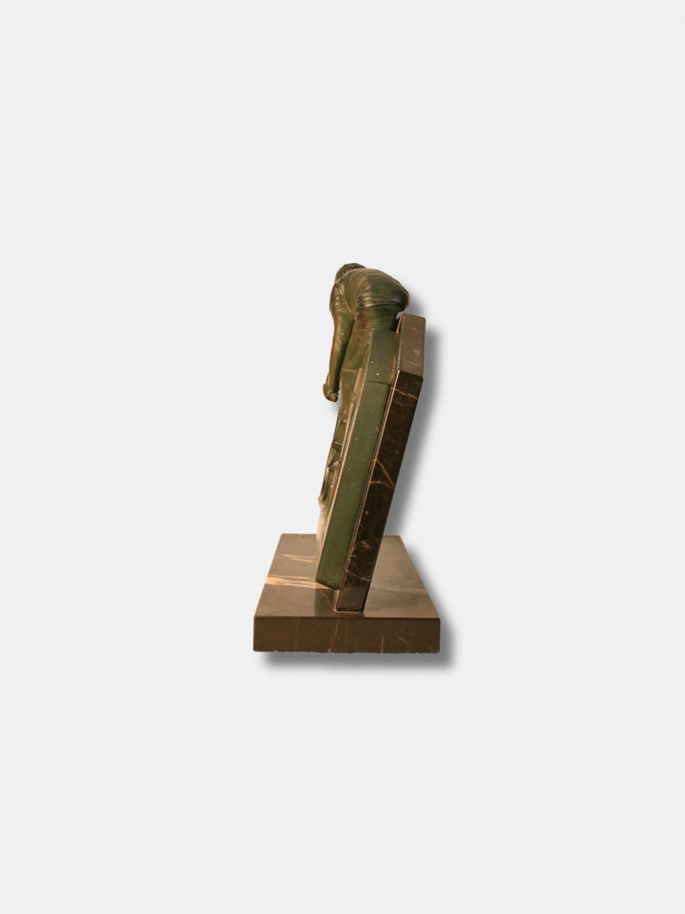 An Art Deco green patinated spelter relief sculpture depicting a cyclist leaning over handlebars, mounted on a veined black onyx plinth. View II
