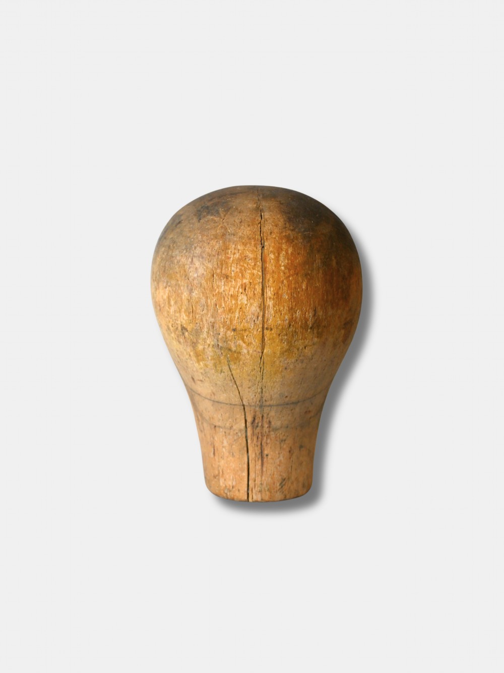 An antique carved wooden millinery head with rendered facial features and a stamped maker inscription on the forehead. View III