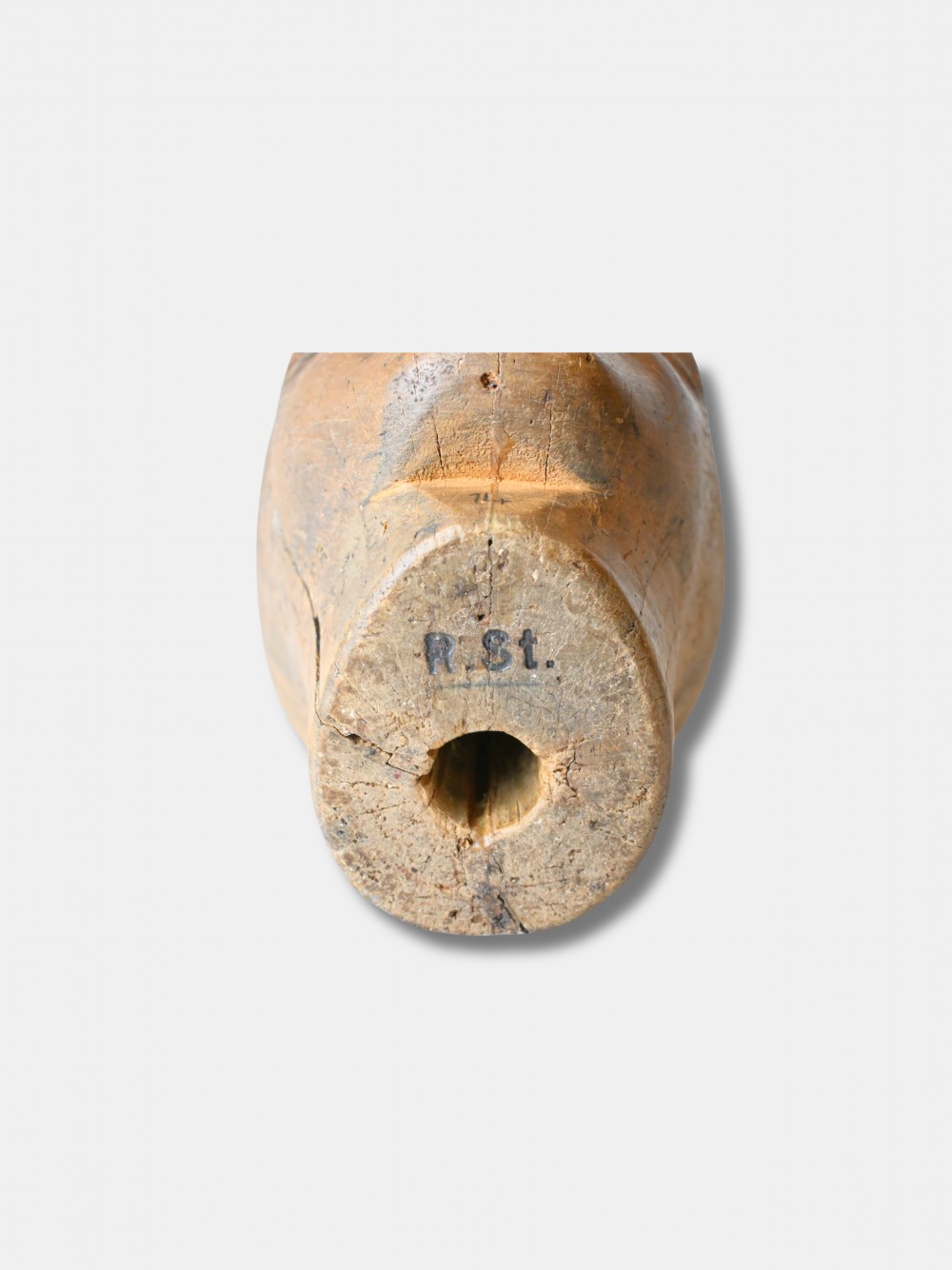 An antique carved wooden millinery head with rendered facial features and a stamped maker inscription on the forehead. View V