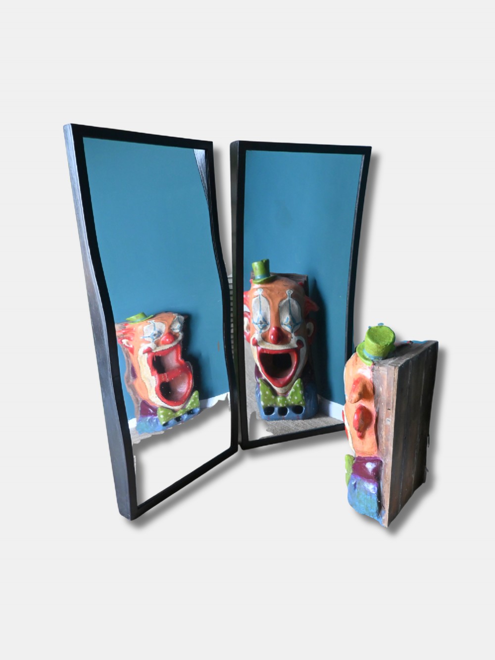 A pair of tall rectangular wall mirrors with dark painted wooden frames and distorted curved glass. View II