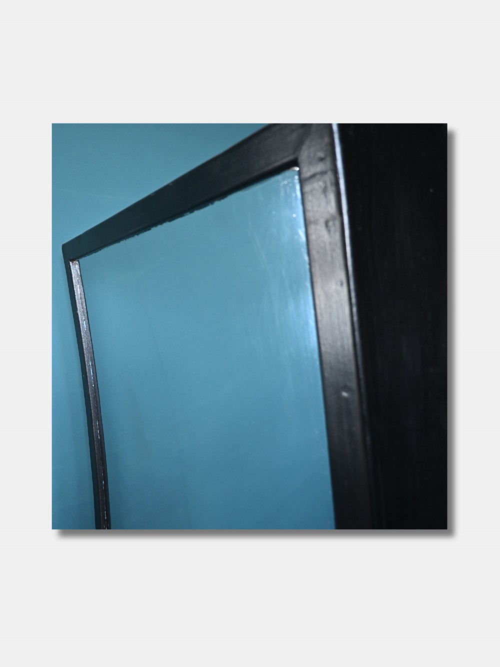 A pair of tall rectangular wall mirrors with dark painted wooden frames and distorted curved glass. View III
