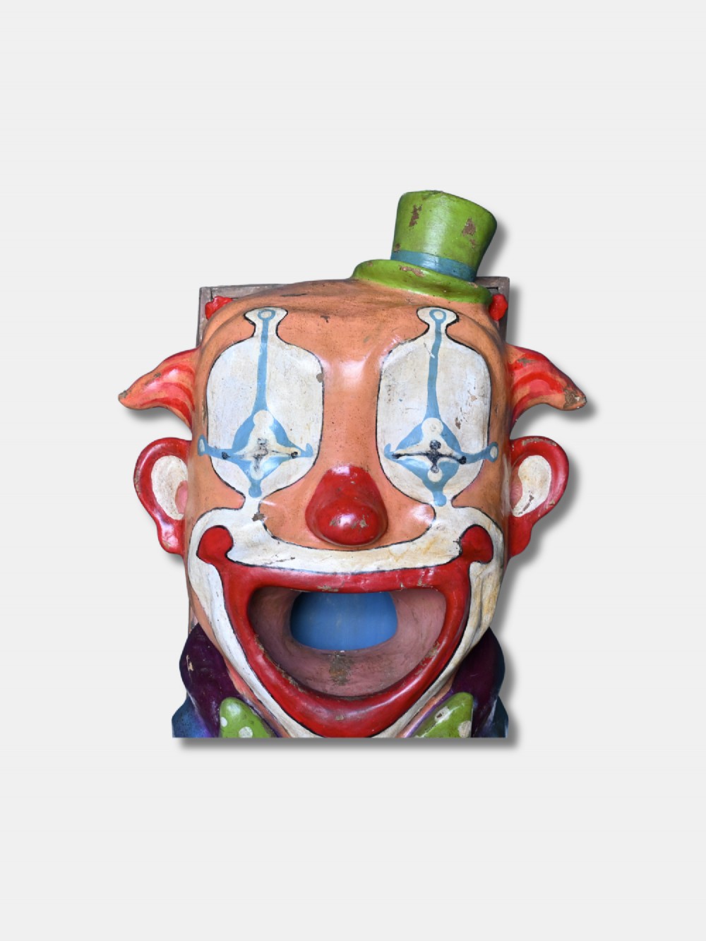 A painted early 20th-century French papier-mache clown head with an open mouth target and green top hat for a fairground ball swallower game. View V