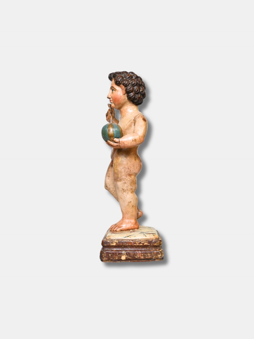 A 17th-century Spanish carved polychrome wood sculpture depicting the standing Infant Jesus holding a blue and gold orb in his left hand and raising his right hand in blessing. View IV