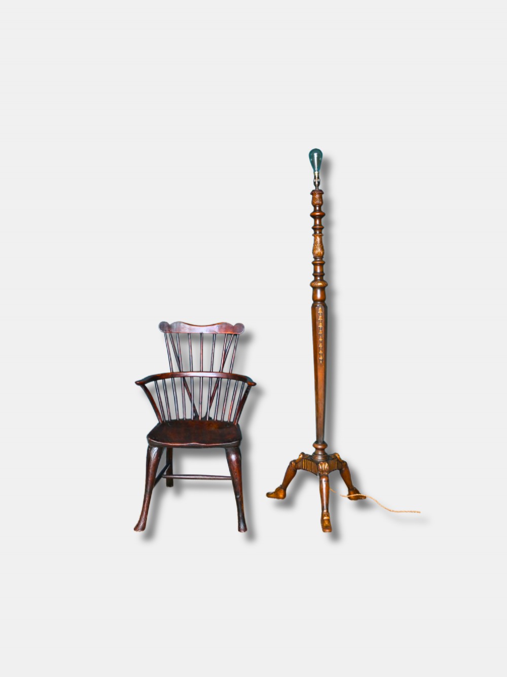 A c. 1920 English turned walnut standard lamp featuring carved parcel-gilt accents and a tripod base with shaped feet.