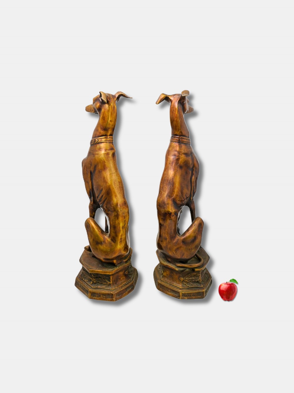 A pair of patinated bronze statues depicting upright seated greyhound dogs resting on relief-decorated octagonal pedestals. View III