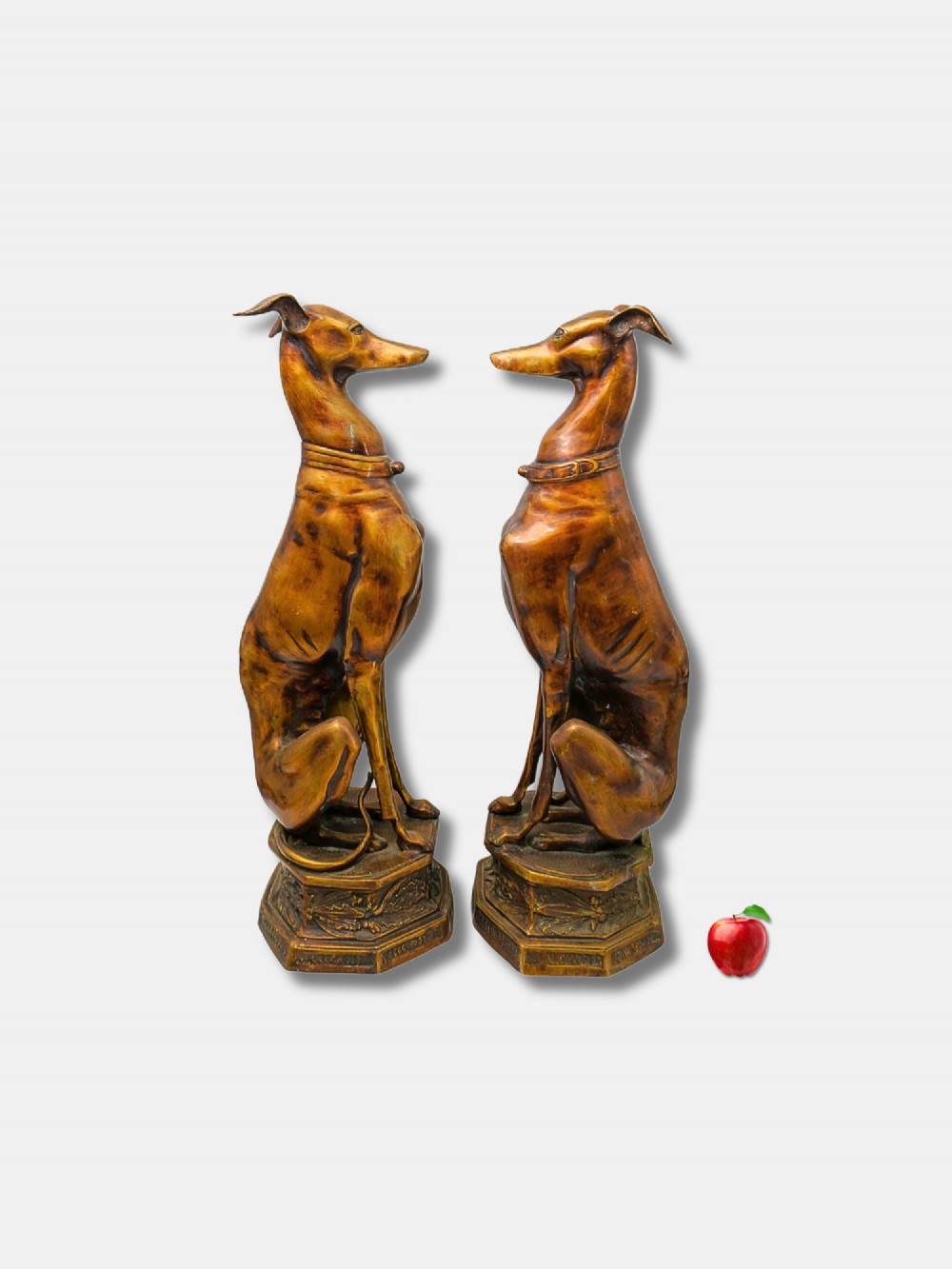 A pair of patinated bronze statues depicting upright seated greyhound dogs resting on relief-decorated octagonal pedestals. View II