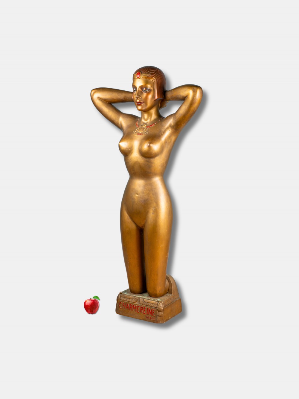 A gold-painted Art Deco plaster female figure kneeling with arms behind her head, mounted on a base inscribed with Charmereine Paris.