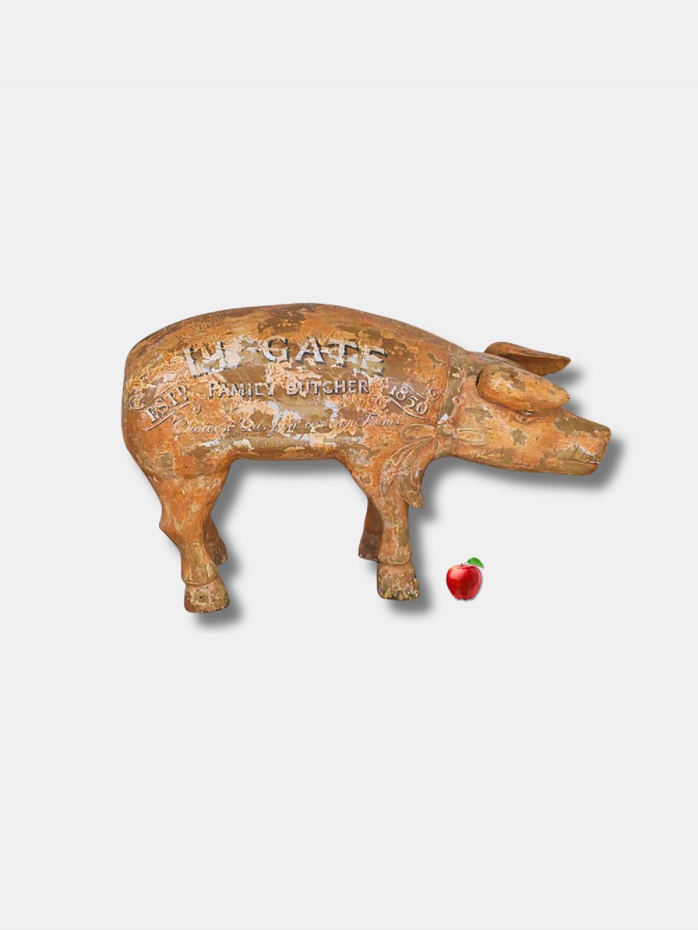 A carved wooden butcher shop trade sign shaped like a pig with a distressed ochre painted finish and white hand-lettered typography.