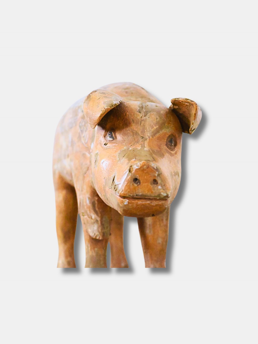 A carved wooden butcher shop trade sign shaped like a pig with a distressed ochre painted finish and white hand-lettered typography. View II