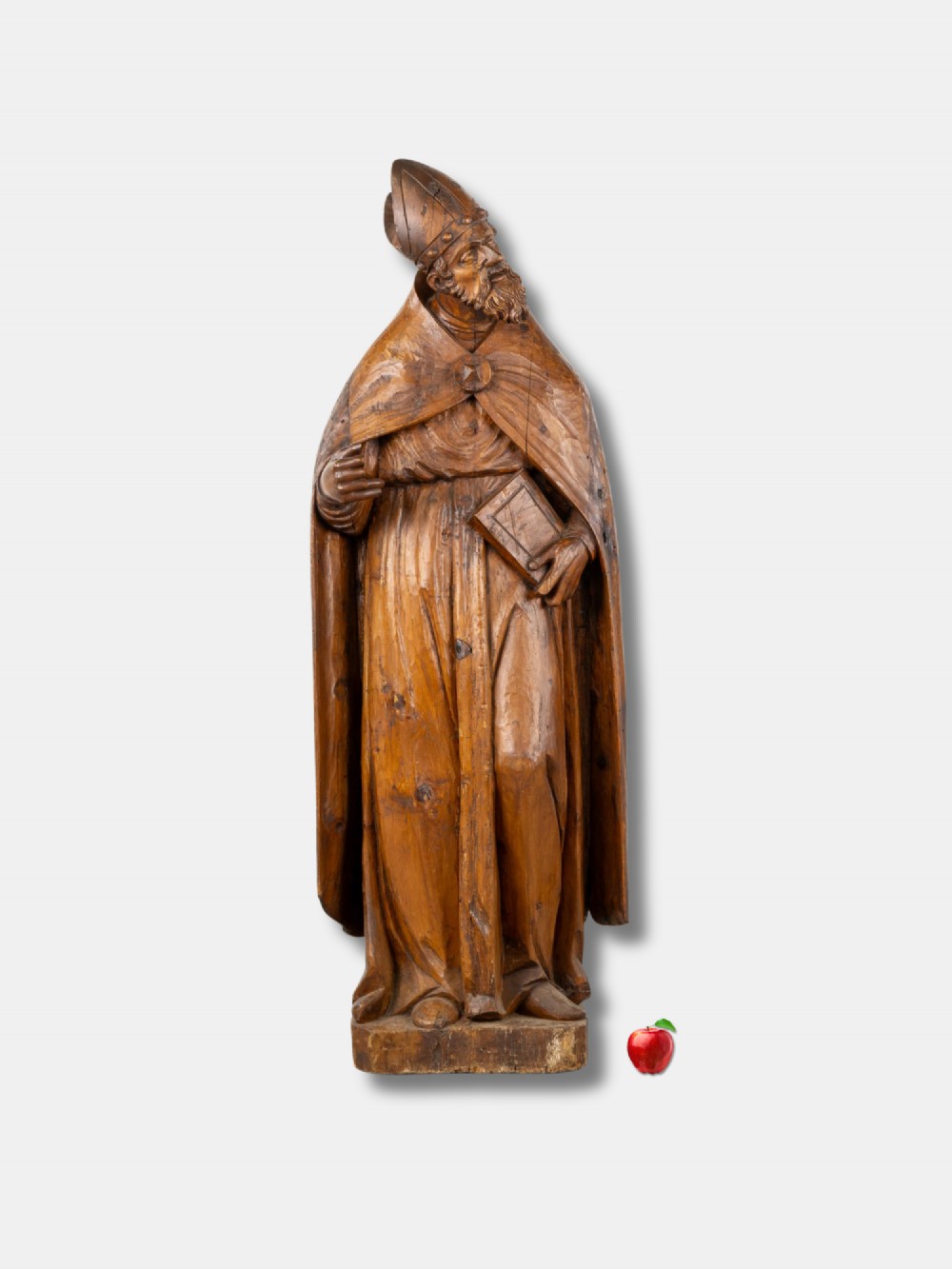 A life-sized 16th-century French carved wood statue depicting Saint Eligius wearing a bishop mitre and draped robes while holding a book.