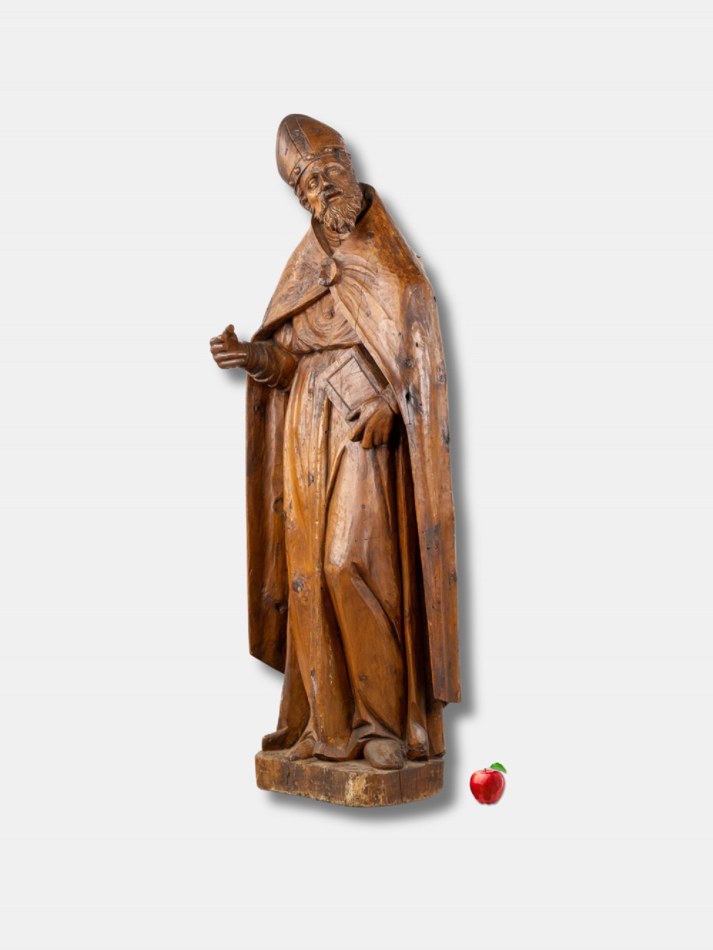 A life-sized 16th-century French carved wood statue depicting Saint Eligius wearing a bishop mitre and draped robes while holding a book. View II
