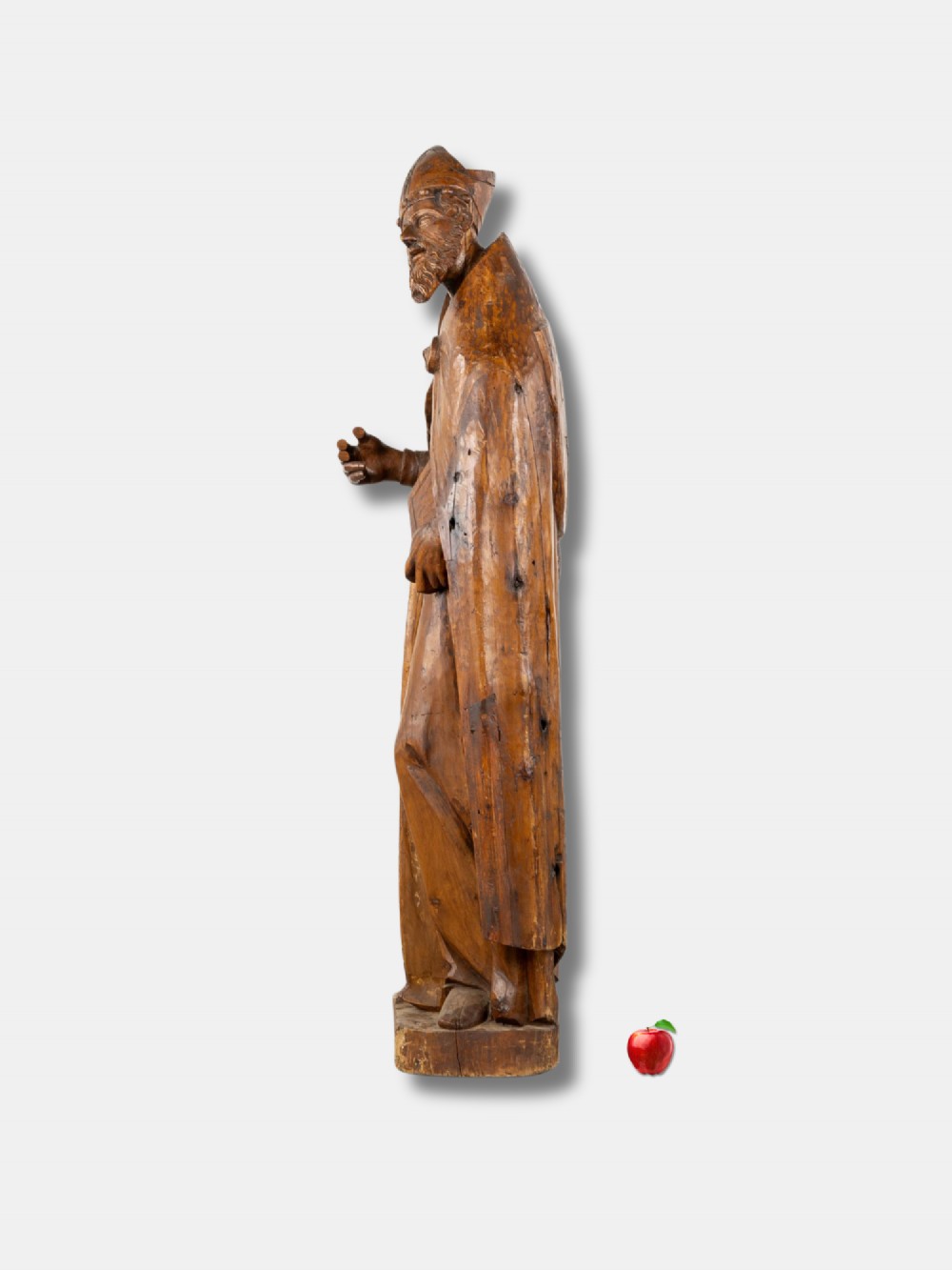 A life-sized 16th-century French carved wood statue depicting Saint Eligius wearing a bishop mitre and draped robes while holding a book. View IV