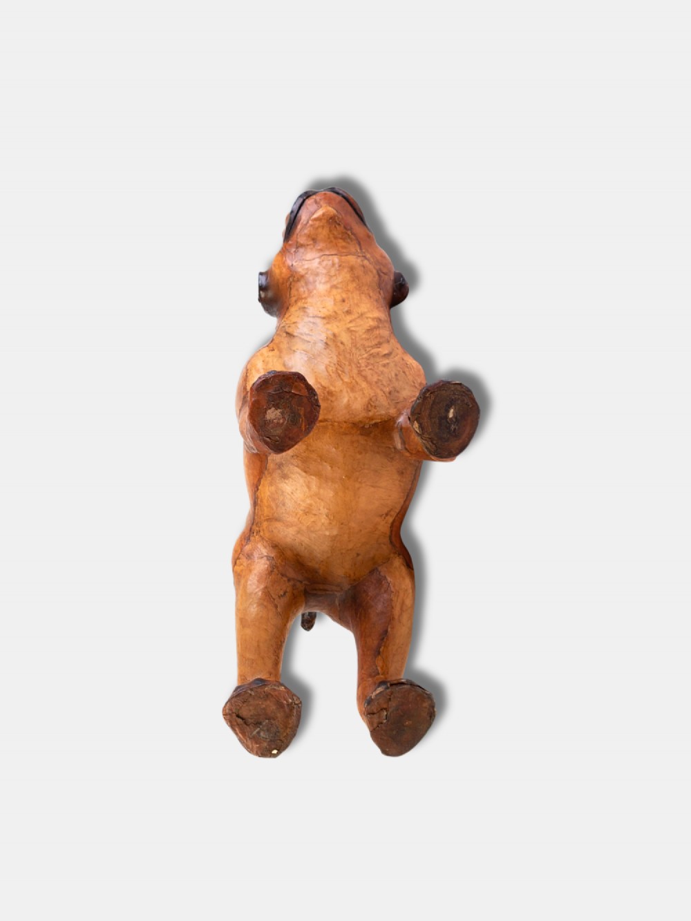 An early twentieth-century handcrafted tan leather footstool shaped as a dog with dark leather ears and muzzle. View IV