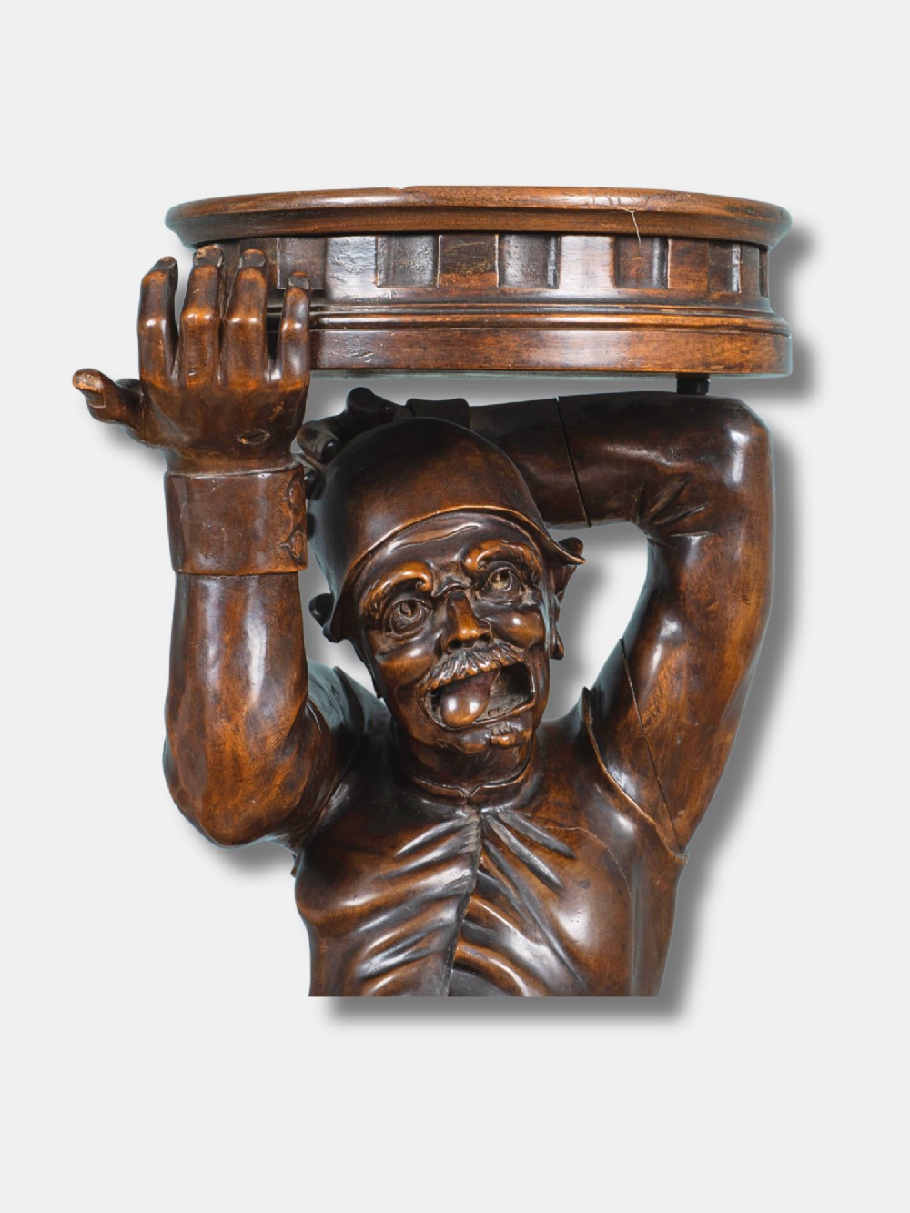 An Italian 19th-century hand-carved dark wood torchere stand depicting a jester figure holding a circular top on a moulded plinth base. View III