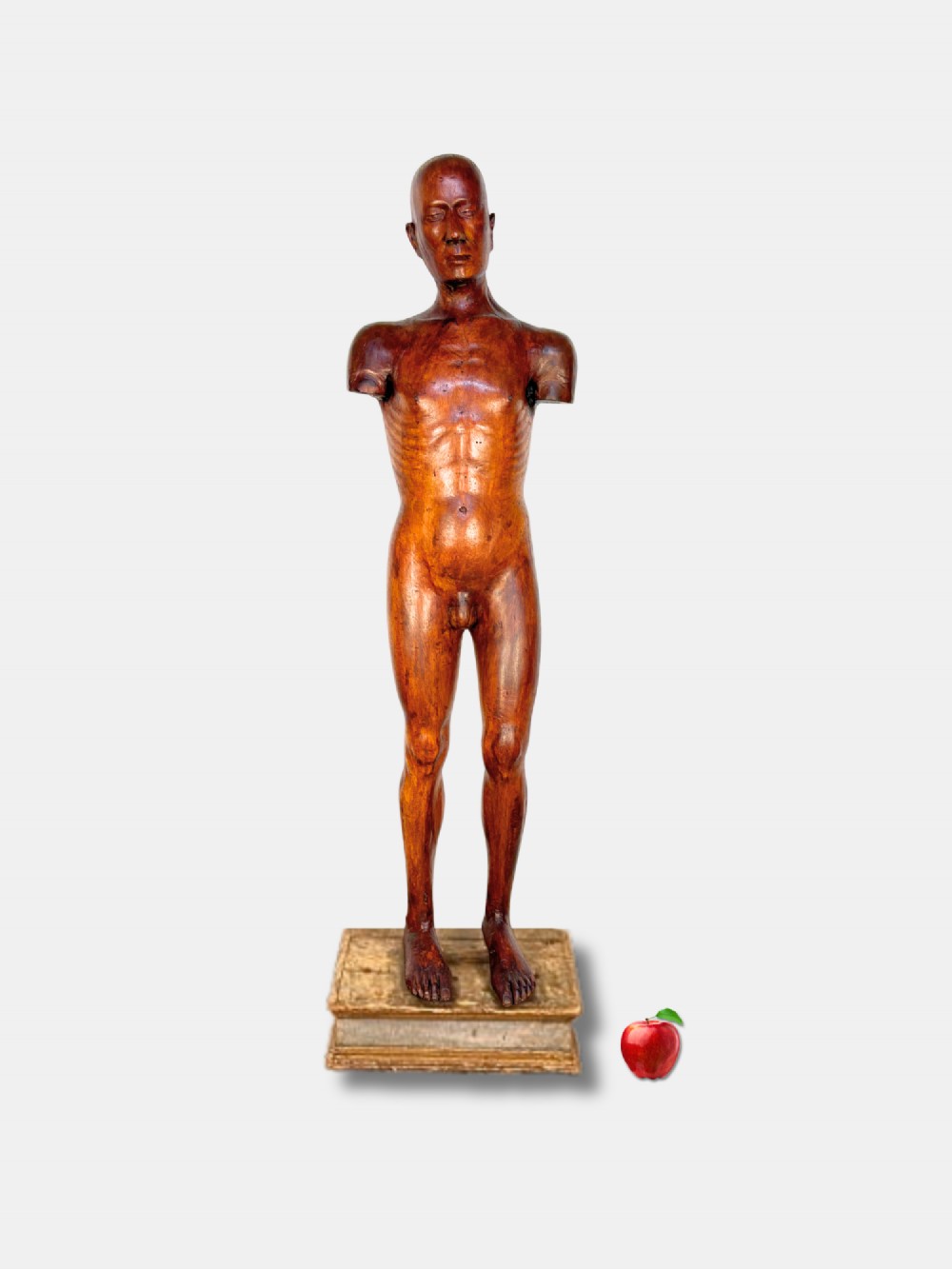 An 18th-century carved wood male figure standing on a square stepped wooden plinth.