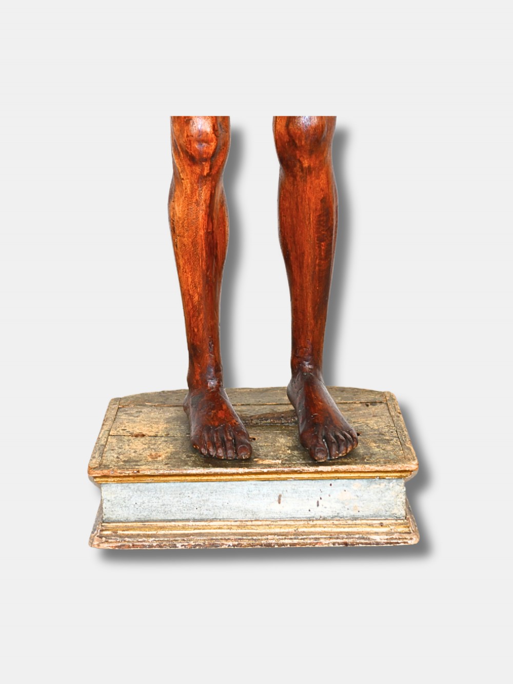 An 18th-century carved wood male figure standing on a square stepped wooden plinth. View V